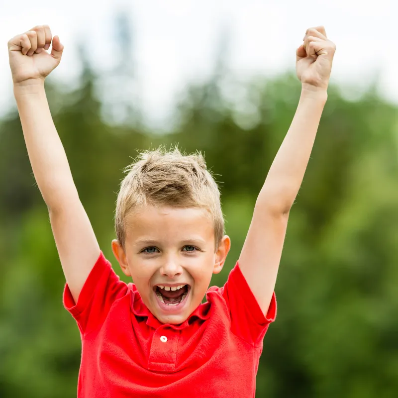 Excited boy cheering outdoors